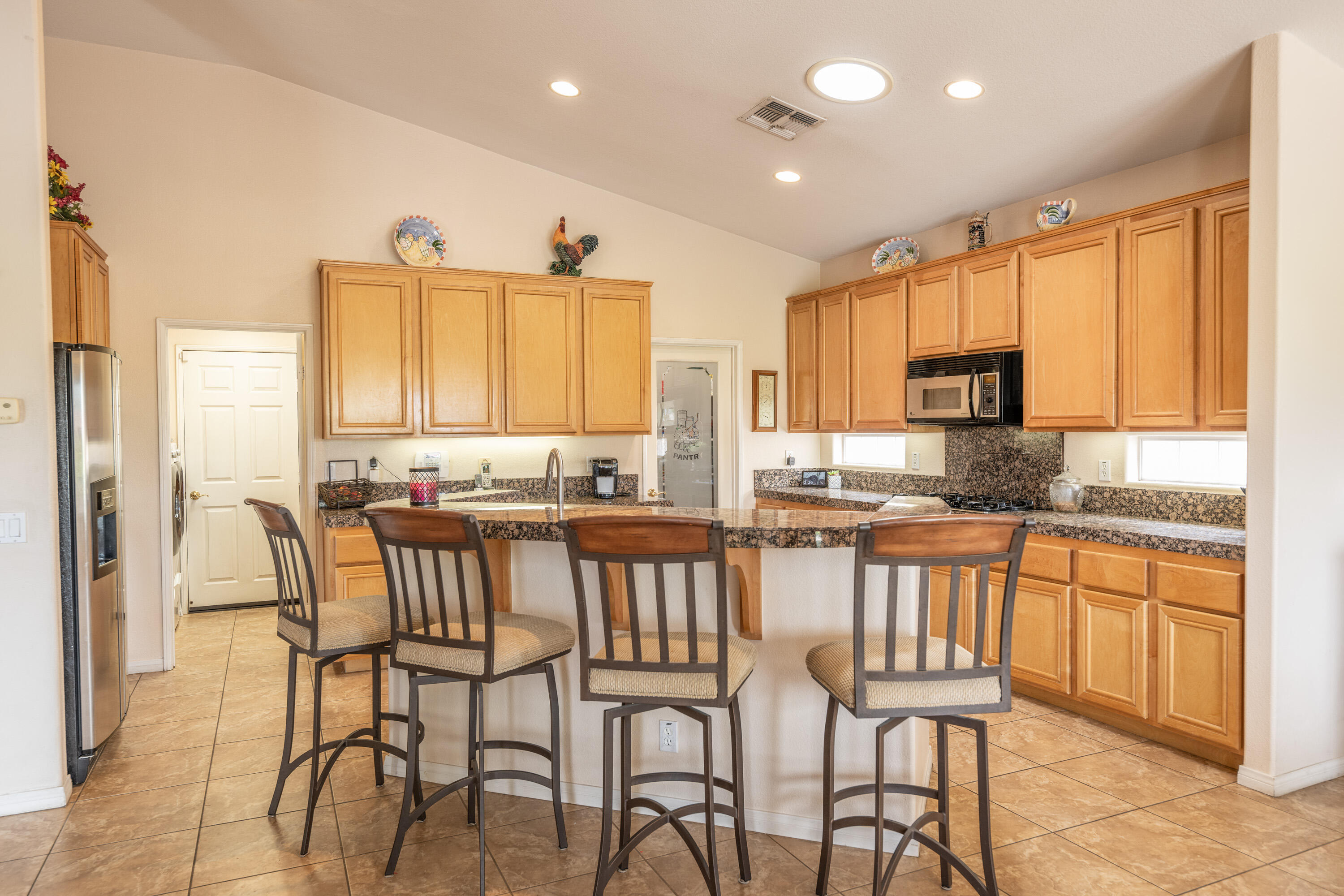 80307 Green Hills Drive Indio, CA 92201 - Photo 15 of 48 a kitchen with stainless steel appliances granite countertop table chairs sink and cabinets