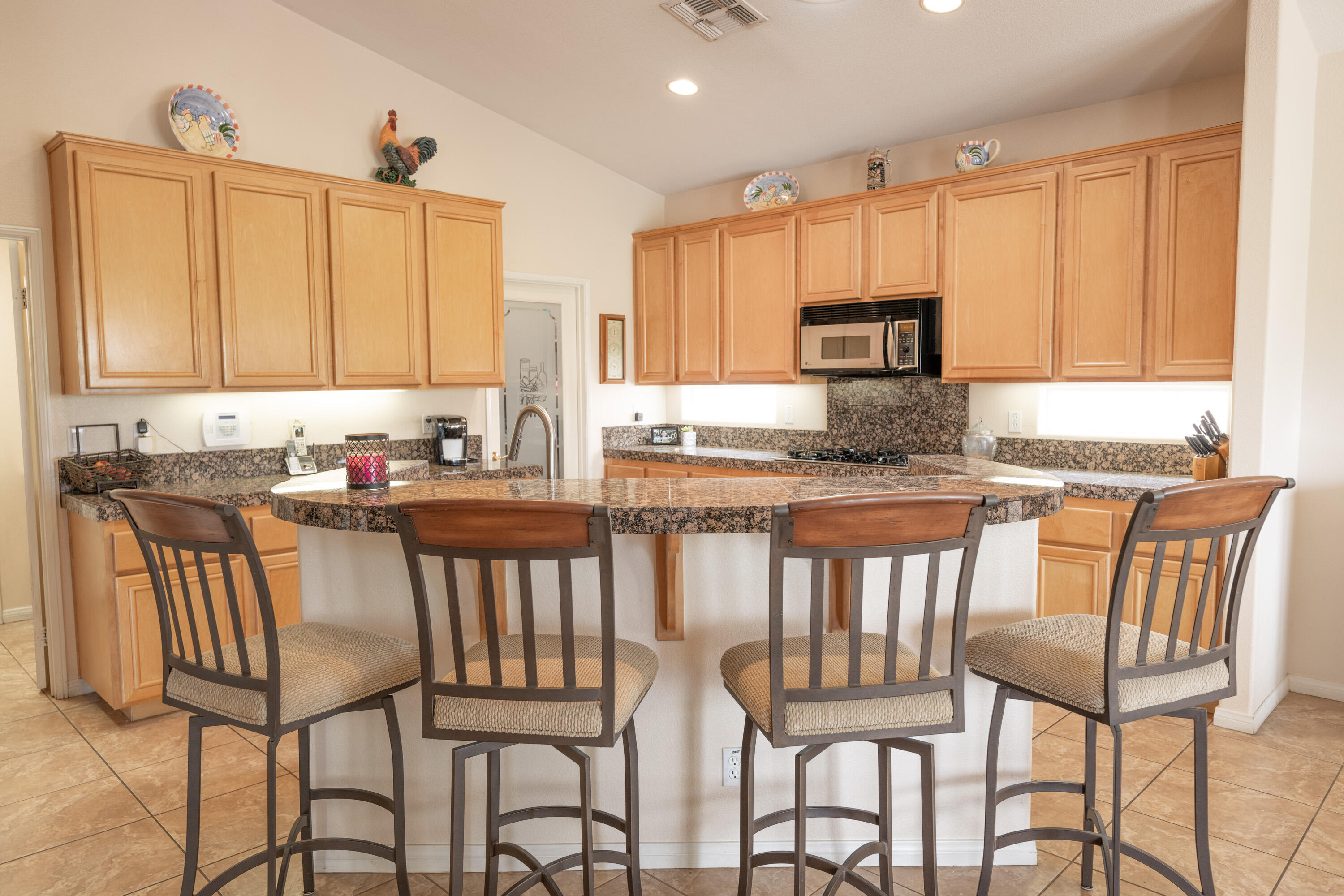 80307 Green Hills Drive Indio, CA 92201 - Photo 16 of 48 a kitchen with stainless steel appliances granite countertop a table chairs and a refrigerator