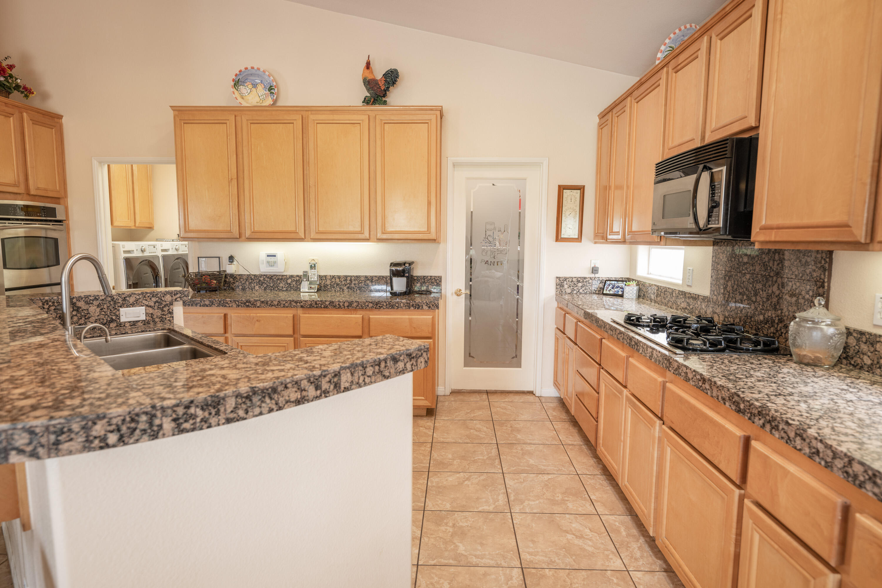 80307 Green Hills Drive Indio, CA 92201 - Photo 18 of 48 a kitchen with stainless steel appliances granite countertop a sink stove and refrigerator
