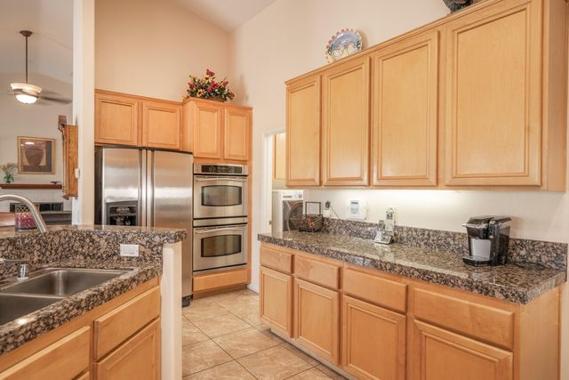a kitchen with granite countertop a sink stainless steel appliances and cabinets