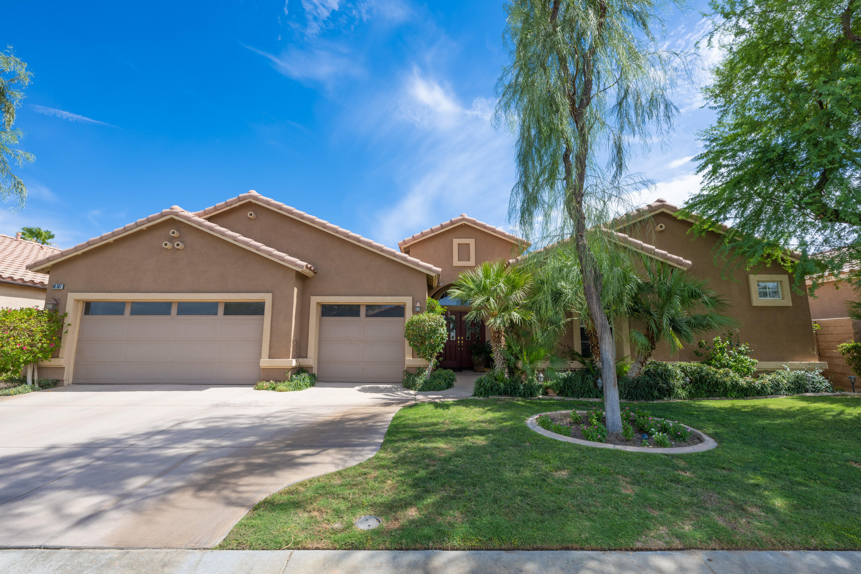 80307 Green Hills Drive Indio, CA 92201 - Photo 9 of 48 a front view of a house with a yard and garage