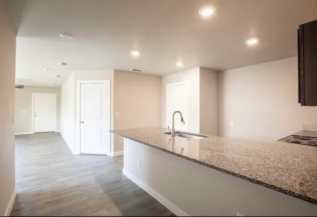 a large kitchen with stainless steel appliances granite countertop a sink and a granite counter tops