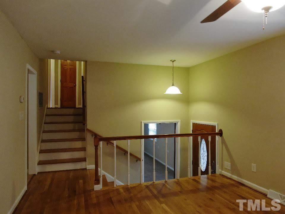 4703 Latimer Road Raleigh, NC 27609 - Photo 2 of 22 a view of a hallway with wooden floor and staircase