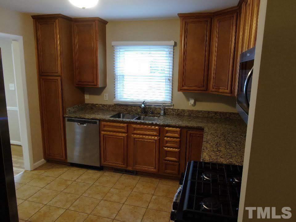 4703 Latimer Road Raleigh, NC 27609 - Photo 12 of 22 a kitchen with granite countertop cabinets and black appliances