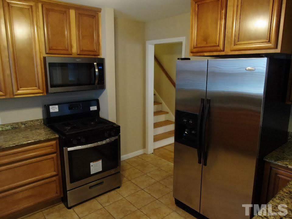 4703 Latimer Road Raleigh, NC 27609 - Photo 13 of 22 a kitchen with stainless steel appliances granite countertop a refrigerator and a stove top oven