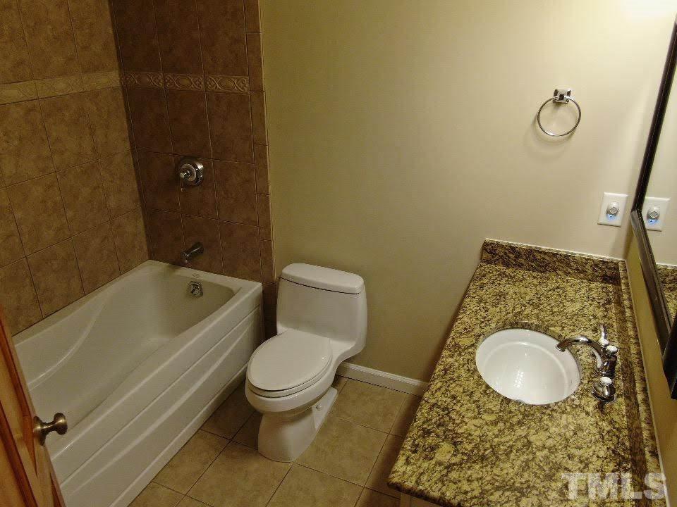 4703 Latimer Road Raleigh, NC 27609 - Photo 15 of 22 a bathroom with a granite countertop toilet and a sink
