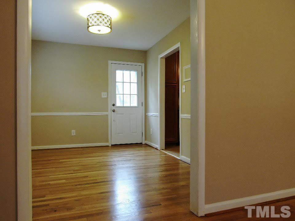 4703 Latimer Road Raleigh, NC 27609 - Photo 4 of 22 an empty room with wooden floor and windows