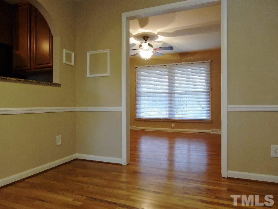 4703 Latimer Road Raleigh, NC 27609 - Photo 5 of 22 an empty room with wooden floor and windows