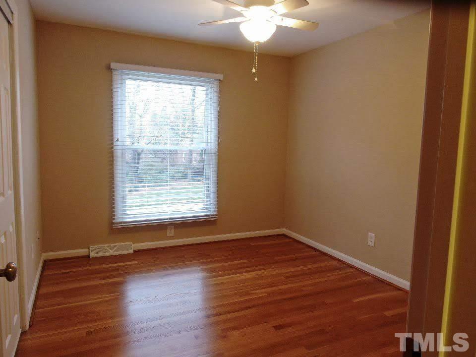 4703 Latimer Road Raleigh, NC 27609 - Photo 7 of 22 a view of an empty room with wooden floor and a window