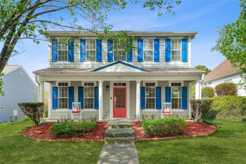 a view of a brick house with a yard and plants