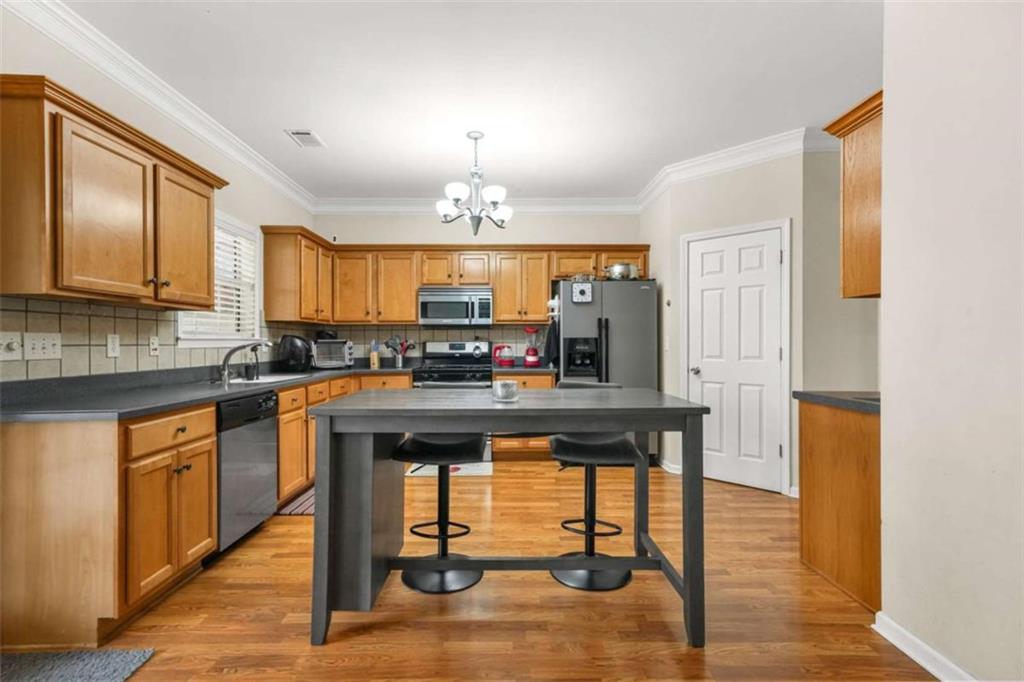535 Anglewood Trace Stockbridge, GA 30281 - Photo 21 of 73 a kitchen with stainless steel appliances granite countertop a stove a sink dishwasher and a refrigerator with wooden floor