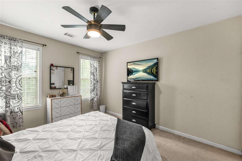 535 Anglewood Trace Stockbridge, GA 30281 - Photo 36 of 73 a bedroom with a bed and a dresser next to a window