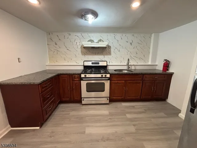 a kitchen with stainless steel appliances granite countertop a stove a sink and a refrigerator