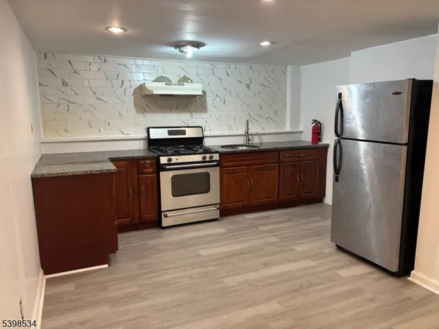 a kitchen with stainless steel appliances granite countertop a refrigerator stove and sink