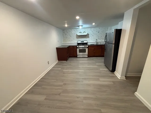 a view of kitchen with stainless steel appliances wooden floor and electronic appliances