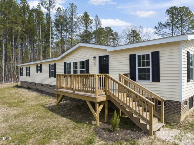 a view of a house with a yard deck and a yard