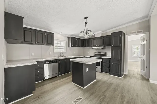 a kitchen with granite countertop a sink cabinets and stainless steel appliances