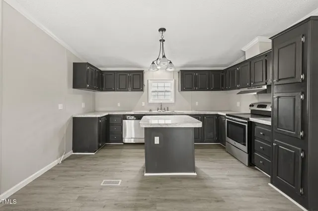 a kitchen with stainless steel appliances granite countertop a stove a sink dishwasher a refrigerator and a oven with wooden floor