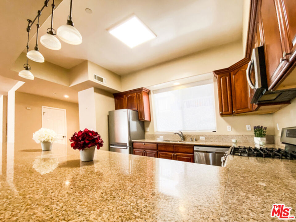 904 East Windsor Road, Unit 103 Glendale, CA 91205 - Photo 8 of 18 a kitchen with stainless steel appliances granite countertop a sink a stove and a wooden floors