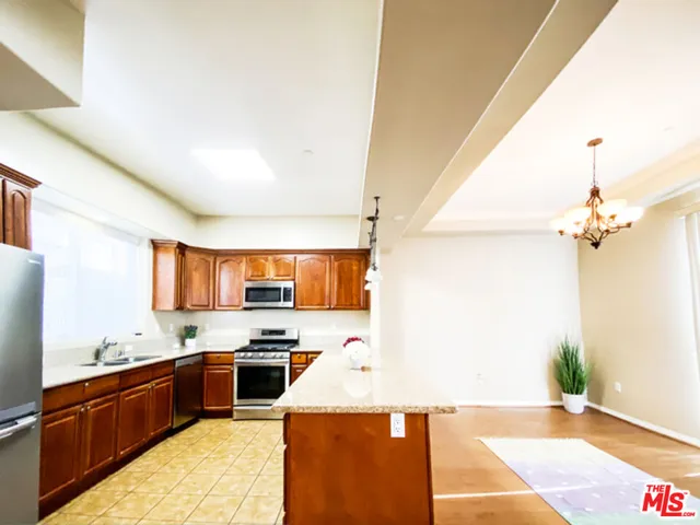 a kitchen with granite countertop a refrigerator and a stove top oven