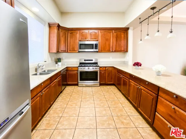 a large kitchen with stainless steel appliances granite countertop a sink and cabinets