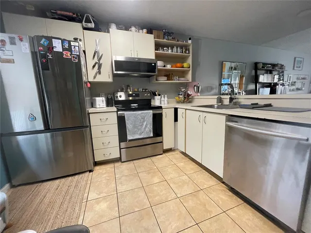a kitchen with stainless steel appliances granite countertop a refrigerator stove and sink