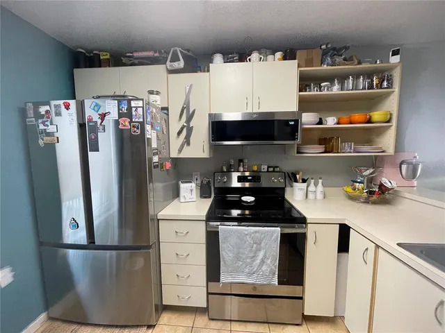a kitchen with stainless steel appliances granite countertop a refrigerator and a stove