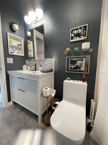a bathroom with a toilet sink and mirror