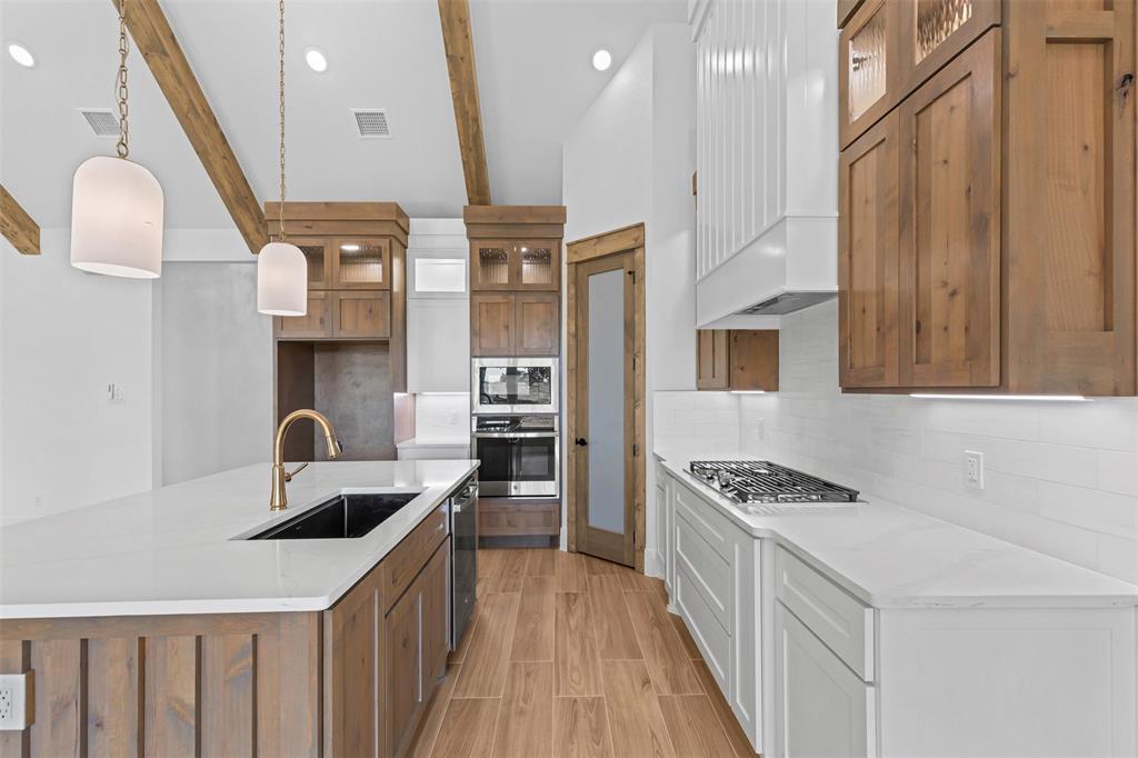 1132 Dobbs Trail Springtown, TX 76082 - Photo 12 of 32 a kitchen with stainless steel appliances a sink a stove top oven a counter space and cabinets