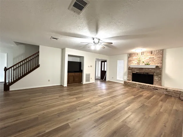 a view of empty room with wooden floor and fireplace