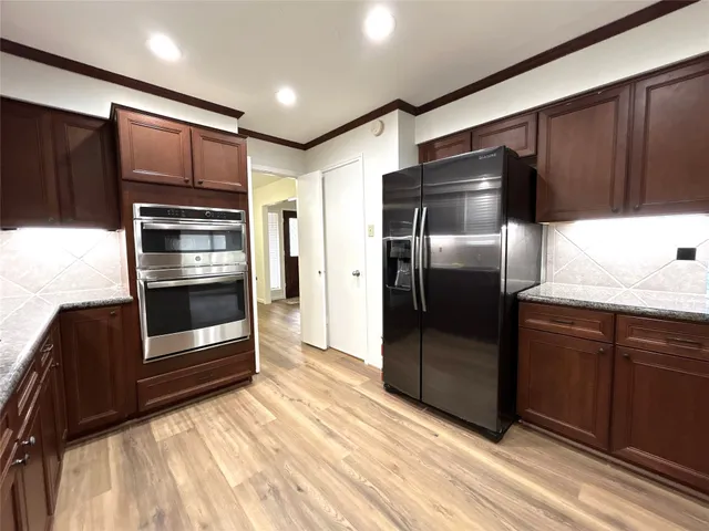 a kitchen with granite countertop stainless steel appliances and refrigerator