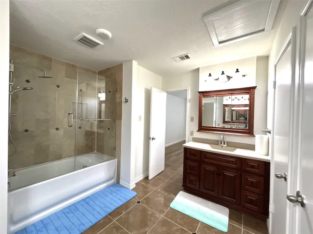 a bathroom with a tub sink and mirror