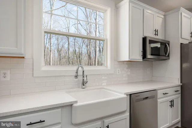a kitchen with stainless steel appliances white cabinets and a sink