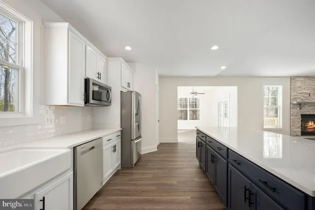 a large kitchen with stainless steel appliances granite countertop a lot of counter space and wooden floor