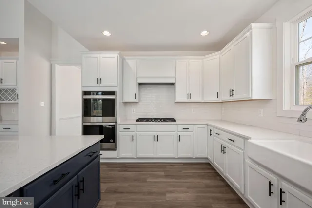 a kitchen with granite countertop white cabinets and white appliances