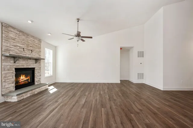 a view of empty room with wooden floor and fireplace