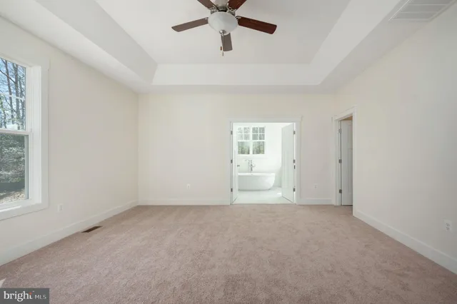an empty room with a window and a ceiling fan