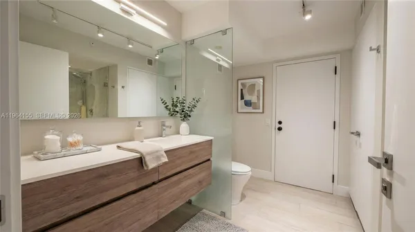 a bathroom with a toilet a sink and mirror