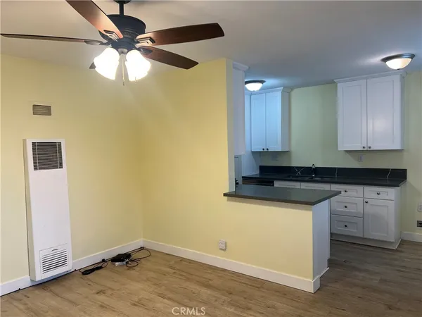 a kitchen with a sink cabinets and wooden floor