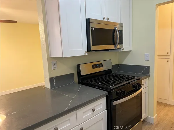 a kitchen with stainless steel appliances granite countertop a stove a microwave and a sink