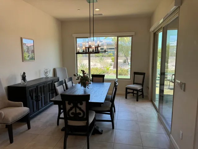 a dining room with furniture a chandelier and window