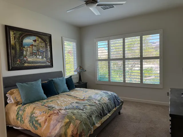 a bedroom with a bed and a painting on the wall