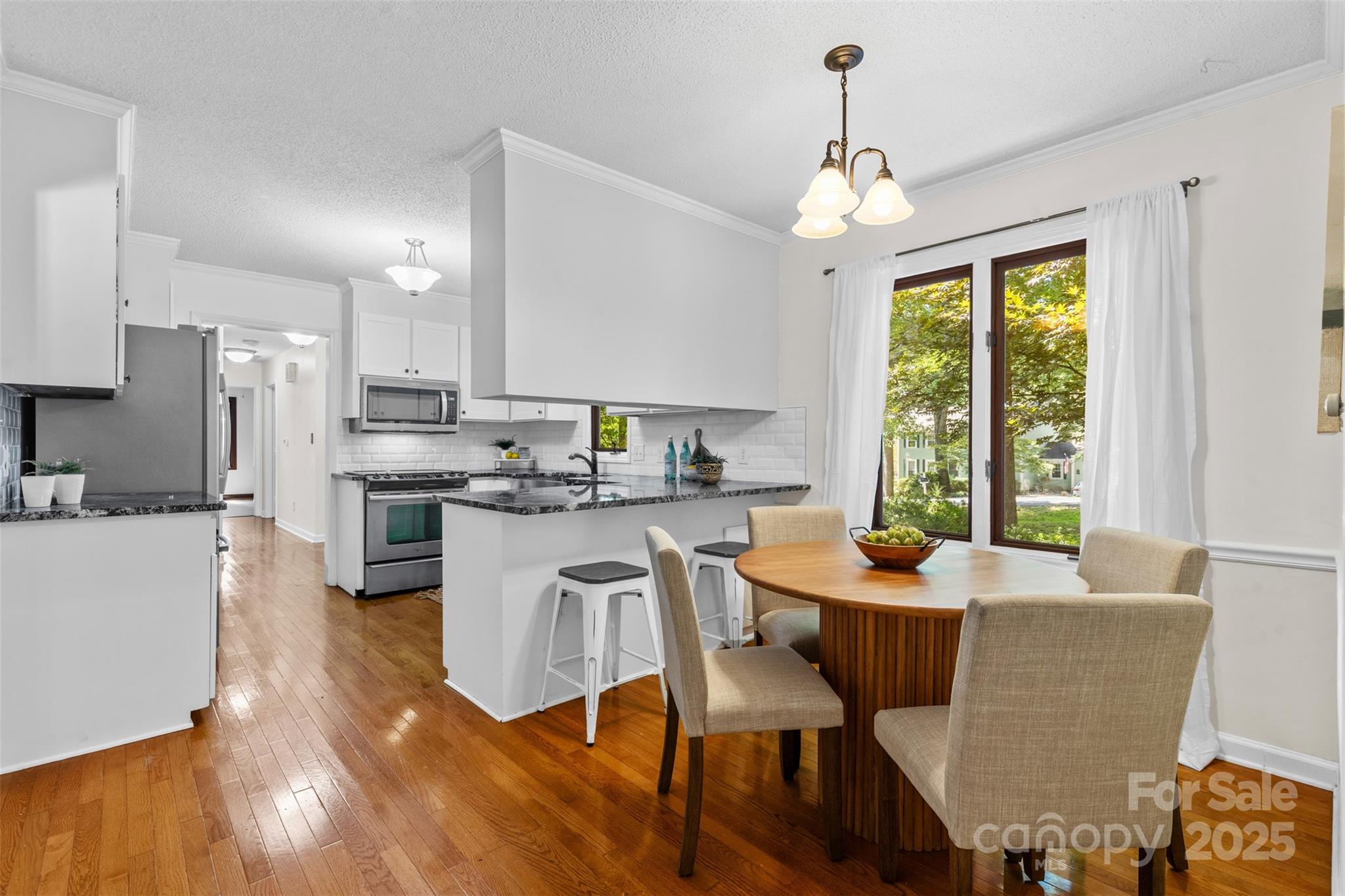 14024 Springwater Drive Matthews, NC 28105 - Photo 11 of 36 a kitchen with stainless steel appliances granite countertop a stove a refrigerator a kitchen island a dining table and chairs