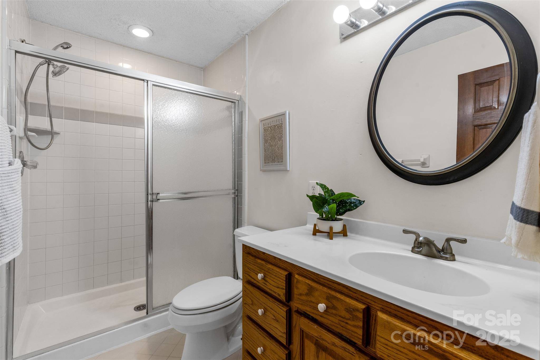 14024 Springwater Drive Matthews, NC 28105 - Photo 13 of 36 a bathroom with a granite countertop toilet sink and shower