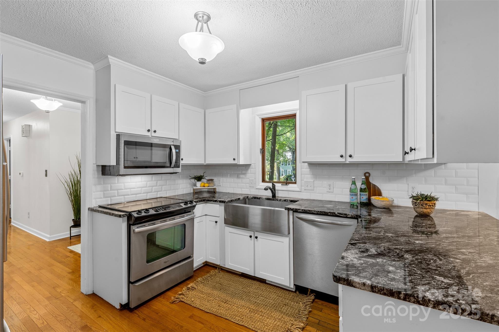 14024 Springwater Drive Matthews, NC 28105 - Photo 8 of 36 a kitchen with stainless steel appliances granite countertop a sink a stove and a refrigerator