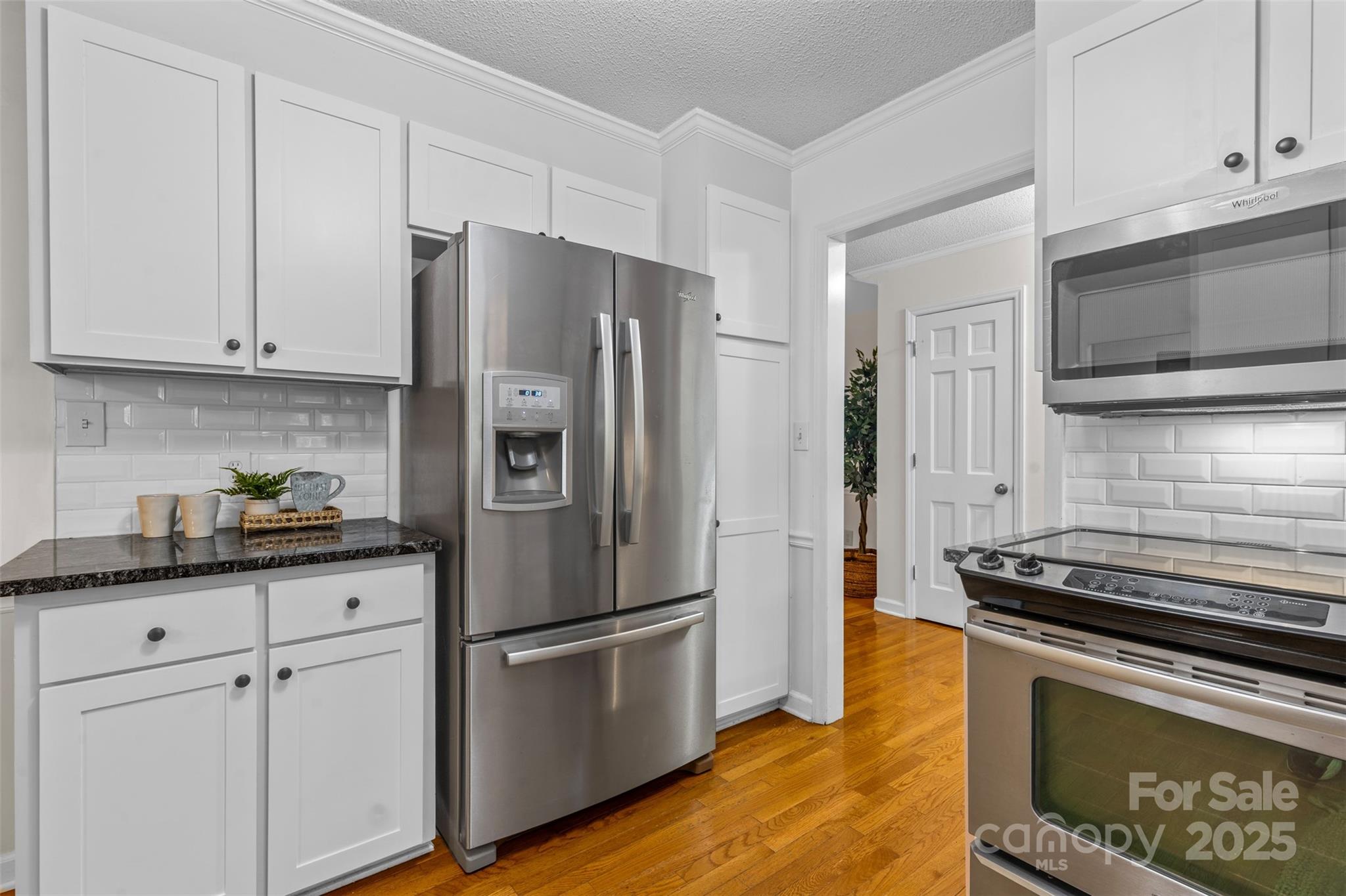 14024 Springwater Drive Matthews, NC 28105 - Photo 9 of 36 a kitchen with stainless steel appliances a refrigerator stove and microwave