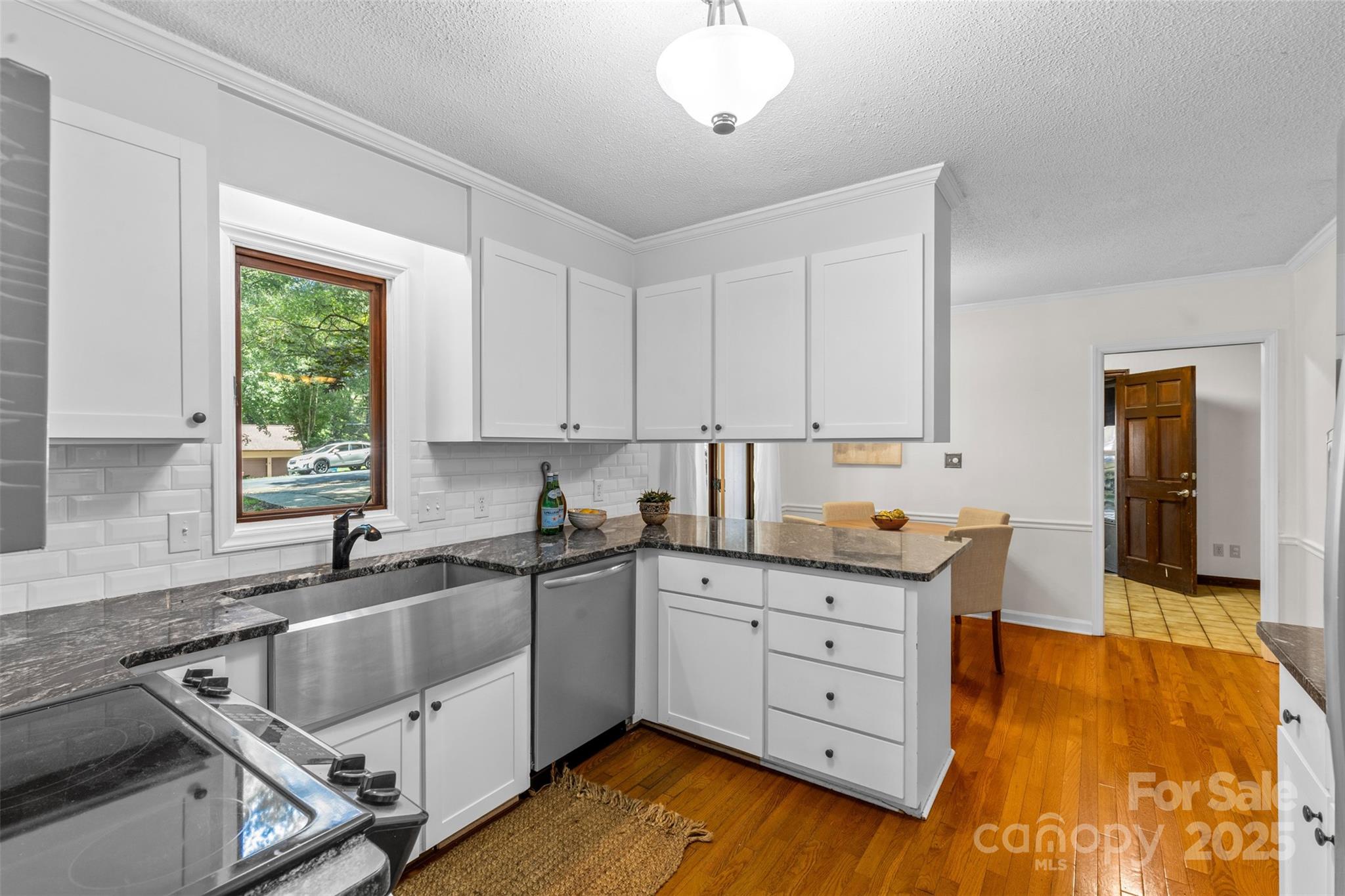 14024 Springwater Drive Matthews, NC 28105 - Photo 10 of 36 a kitchen with granite countertop a sink a window and cabinets