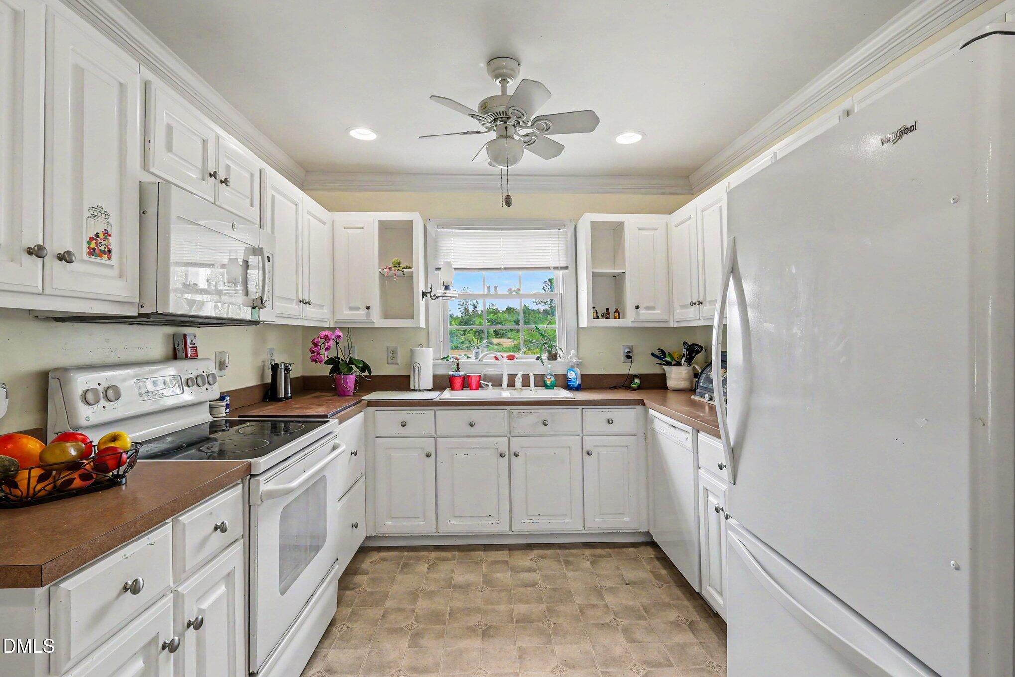 1750 Tom Oakley Road Timberlake, NC 27583 - Photo 11 of 31 a kitchen with stainless steel appliances a white cabinets and a sink
