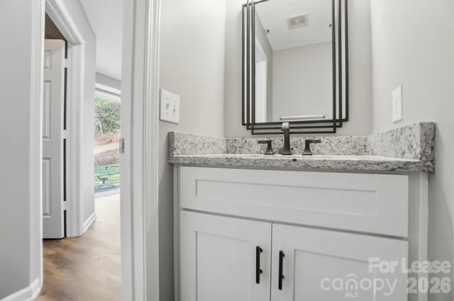 a bathroom with a granite countertop sink and a mirror