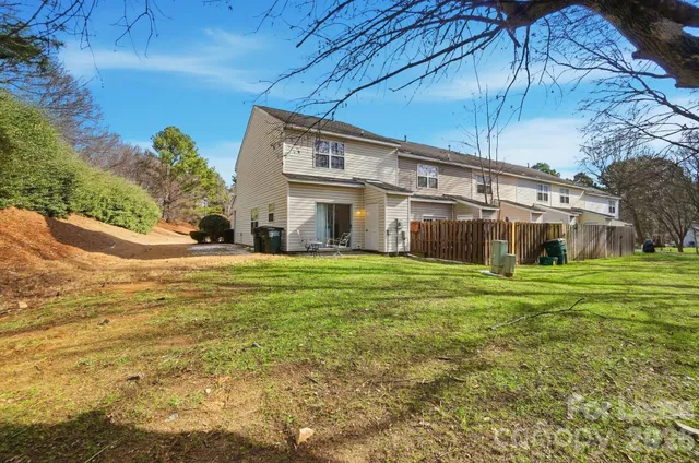 a front view of house with yard and trees in the background